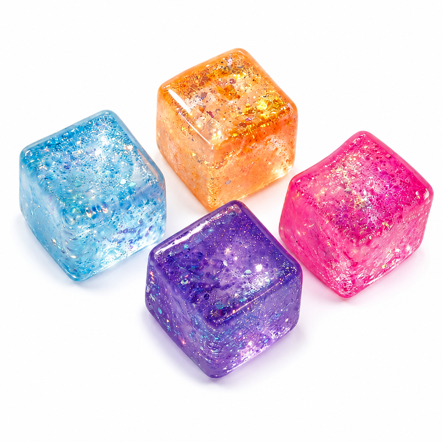 Four translucent glitter squeeze cubes in blue orange purple and pink on white