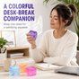 Adult using a purple glitter squeeze cube at a home office desk